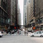 Dynamic cityscape showcasing pedestrians walking among skyscrapers and vehicles.